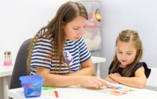 Children speech therapy concept. Preschooler practicing correct pronunciation with a female speech therapist.