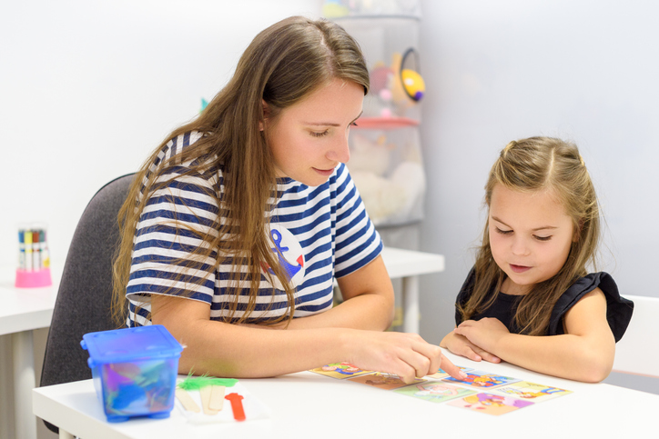 Children speech therapy concept. Preschooler practicing correct pronunciation with a female speech therapist.